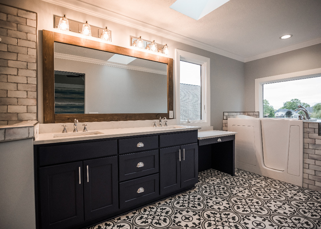 Lakehouse Bathroom renovation with black cabinetry, white bathroom vanity, and black and white floor tile design by PH Design, custom construction and renovation company in Canton, OH