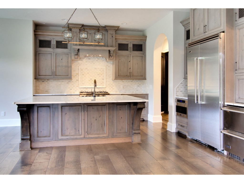 Kitchen with island of Woodford, tudor style home by PH Design, custom construction home builders in Canton, OH
