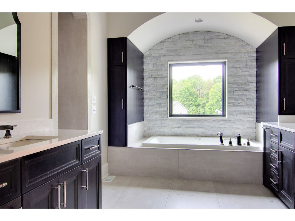Modern bathroom with bathtub of Woodford, tudor style home by PH Design, custom construction home builders in Canton, OH