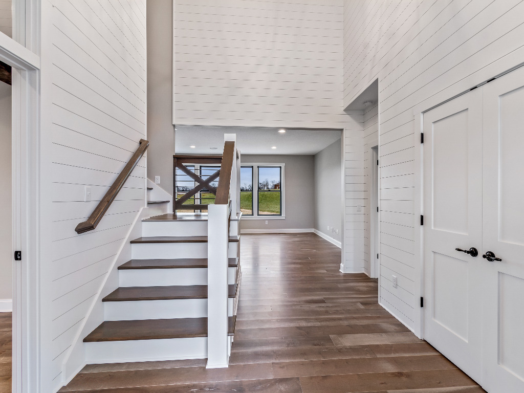 Entryway of Modern Farmhouse Home with hardwood flooring and black and white walls and doors by PH Design, custom construction home builders in Canton, OH