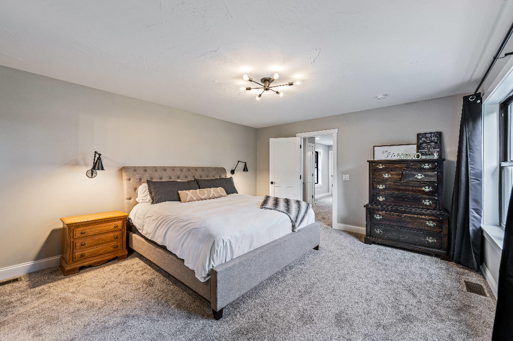 Furnished bedroom with carpet in Modern Craftsman style home by PH Design, custom construction home builders in Canton, OH