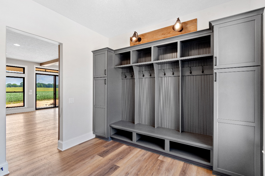 Mudroom with a built-in bench leads to the three-car garage